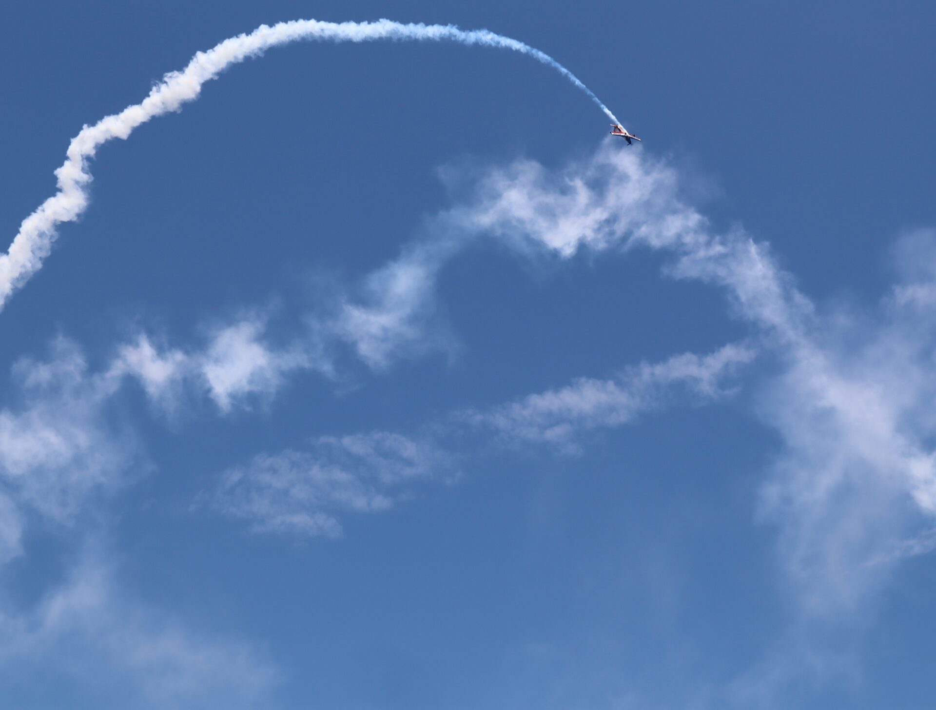 Plane drawing a smoke trail across the Florida sky